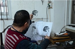 徽艺坊铁画大师凌晓华正在对比打制的人物像