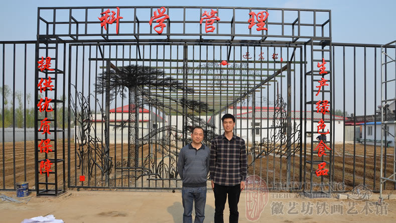 徽艺坊铁画师傅在迎客松铁艺大门前合影